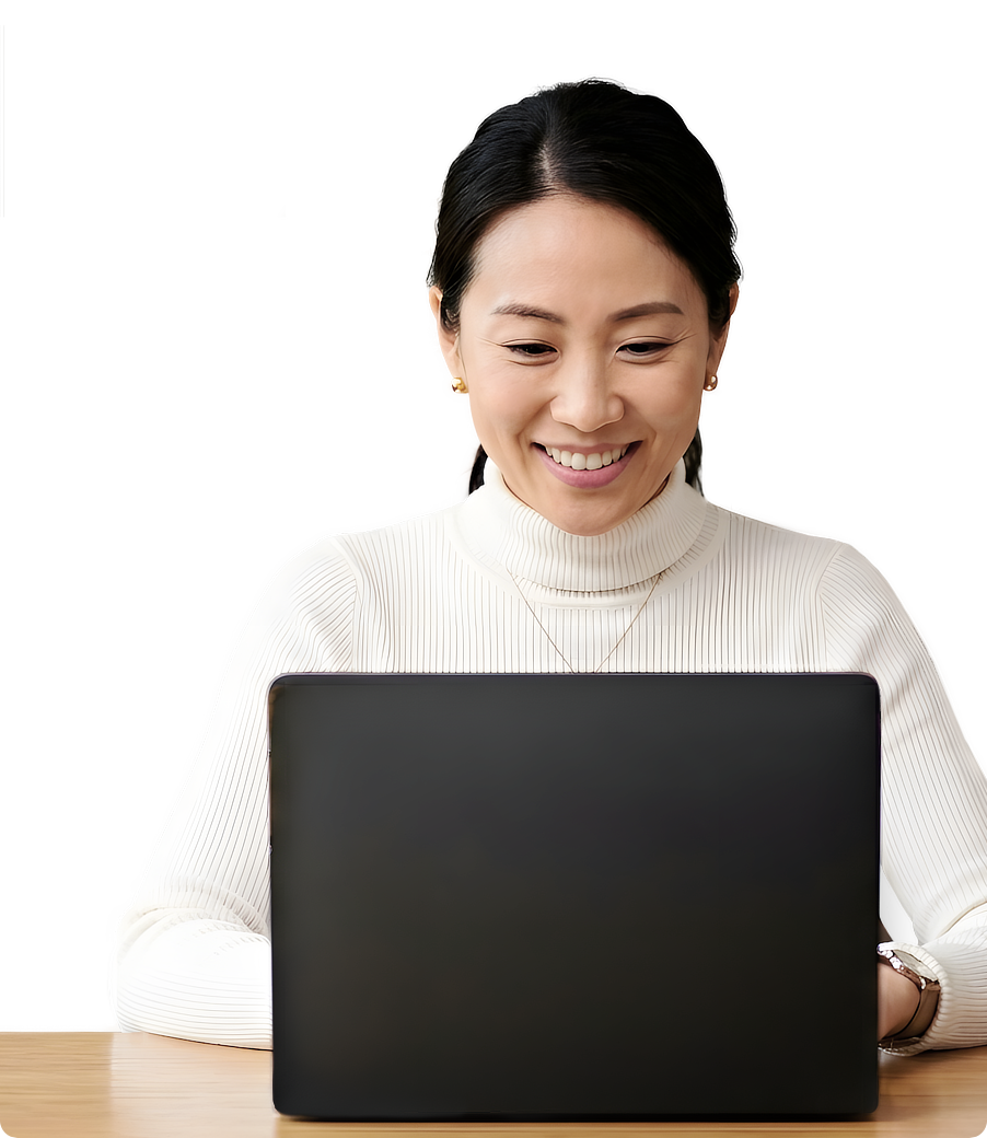 A woman smiling while looking at her laptop.